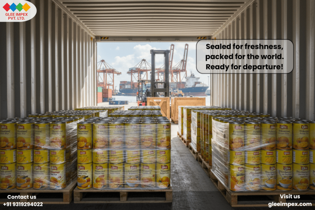 The Global Gold Standard: Why Glee Impex is the Preferred Organic Mango Pulp Exporter for Premium Food Brands The interior of a shipping container at a busy port, fully loaded with pallets of canned products ready for international shipment by an organic mango pulp exporter.