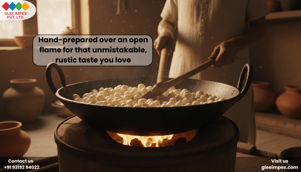 A person hand-preparing makhana in a large iron wok over an open flame to create a rustic taste, showcasing the traditional methods used by a premium lotus seeds supplier.